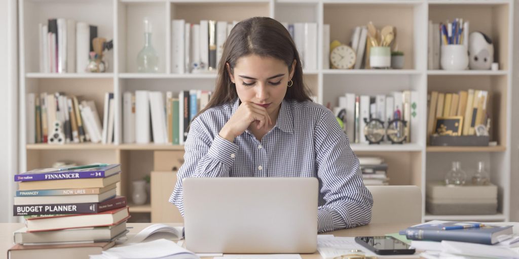 Student managing finances with a laptop and budget planner.